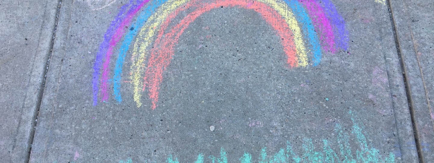 rainbow drawn in chalk on a sidewalk